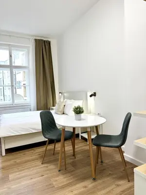 a bedroom with a bed and a table and chairs at Cozy One-Room Apartment in heart of Prague in Prague