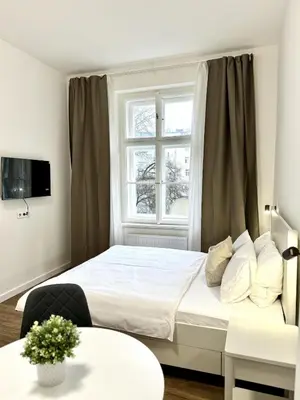 a bedroom with a white bed and a window at Cozy One-Room Apartment in heart of Prague in Prague