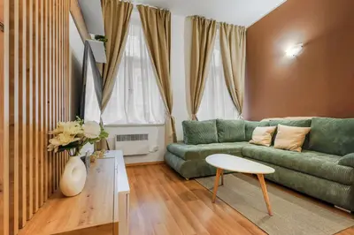 a living room with a green couch and a table at Cozy stay near City Center - Žižkov in Prague