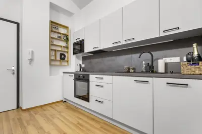 a kitchen with white cabinets and stainless steel appliances at Cozy stay near City Center - Žižkov in Prague