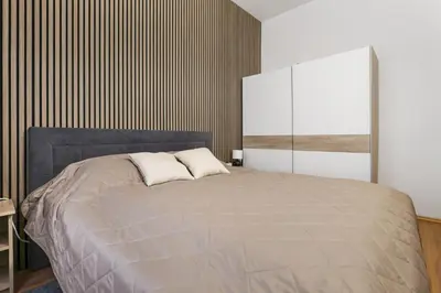 a bedroom with a large bed and a wooden wall at Cozy stay near City Center - Žižkov in Prague
