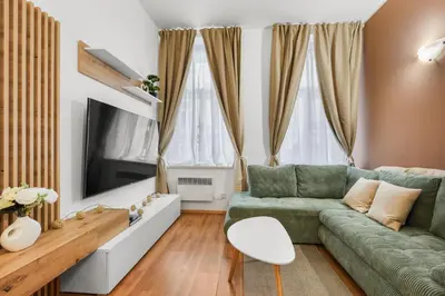 a living room with a green couch and a flat screen tv at Cozy stay near City Center - Žižkov in Prague
