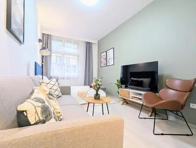 a living room with a couch and a tv at Old Town 2 BDR, free coffee in Prague
