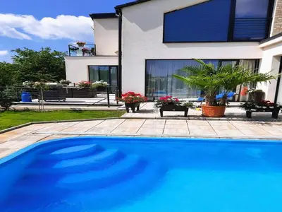 a blue swimming pool in front of a house at Holiday Home in Kladno with Private Pool in Lány