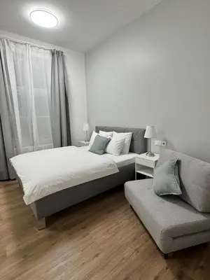 a white bedroom with a bed and a couch at Elegant & Classy 1BR Apartment in Central Prague in Prague