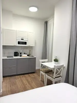 a kitchen with white cabinets and a table with chairs at Elegant & Classy 1BR Apartment in Central Prague in Prague