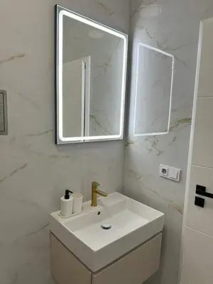 a white bathroom with a sink and a mirror at Elegant & Classy 1BR Apartment in Central Prague in Prague