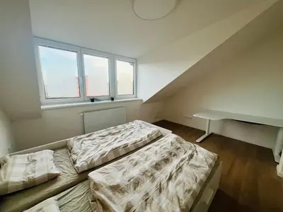 two beds in a room with two windows at New sunny rooftop apartment with a terrace 10 minutes from city centre in Prague
