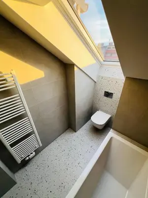 a bathroom with a toilet and a window at New sunny rooftop apartment with a terrace 10 minutes from city centre in Prague