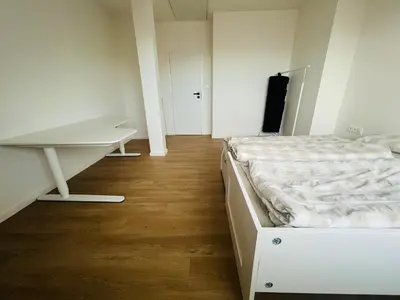 a white bedroom with a bed and a desk at New sunny rooftop apartment with a terrace 10 minutes from city centre in Prague