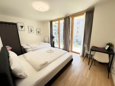 a bedroom with a bed and a desk and a window at Nest Home Prague center in Prague