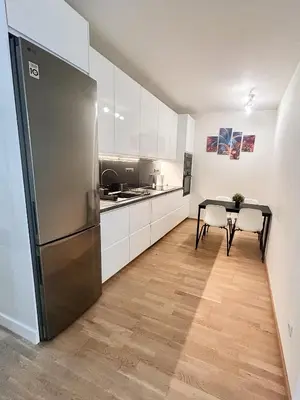 a kitchen with a refrigerator and a table with chairs at Nest Home Prague center in Prague