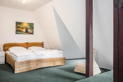 a bedroom with a wooden bed in a room at Hotel Konopiště Nová Myslivna in Benešov