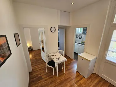 a living room with a table and a clock on a wall at Jezerka Apartments - Free Parking - Easy Access to Center in Prague