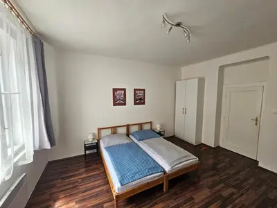 a bedroom with a bed in a room with wooden floors at Jezerka Apartments - Free Parking - Easy Access to Center in Prague