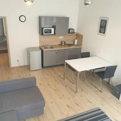a living room with a table and a kitchen at Greg Apartments Kampa Prague in Prague