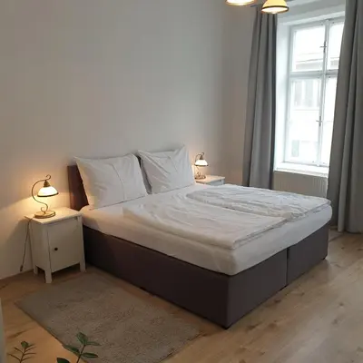 a bedroom with a large bed with two night stands at Greg Apartments Kampa Prague in Prague