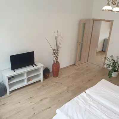 a living room with a television on a white cabinet at Greg Apartments Kampa Prague in Prague