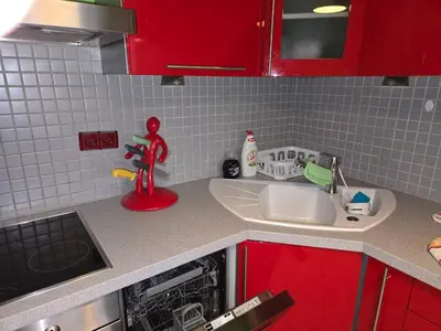 a kitchen counter with a sink and red cabinets at Spacious two-room apartment in Prague in Prague