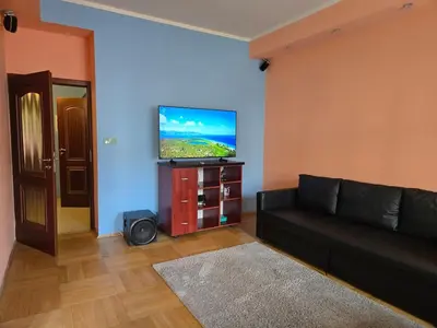 a living room with a black couch and a flat screen tv at Spacious two-room apartment in Prague in Prague
