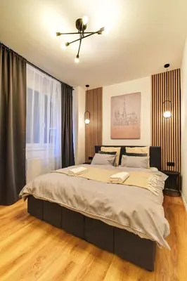 a bedroom with a large bed with a ceiling fan at Long Street Deluxe Suite Apartment Prague in Prague