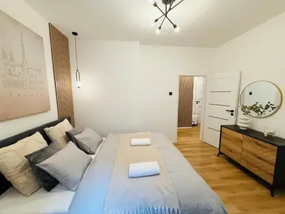 a bedroom with a large bed and a mirror at Long Street Deluxe Suite Apartment Prague in Prague
