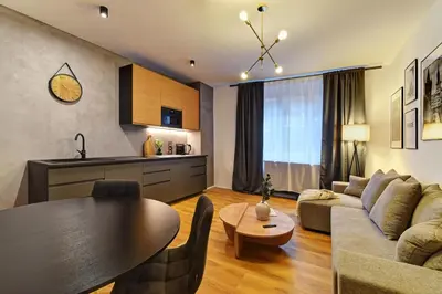 a living room with a couch and a table and a kitchen at Long Street Deluxe Suite Apartment Prague in Prague