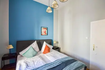 a blue bedroom with a bed with colorful pillows at Celebration Flat by Ruterra in Prague