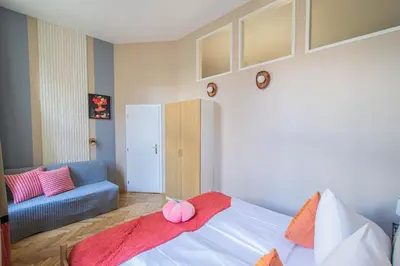 a bedroom with a bed and a couch at Celebration Flat by Ruterra in Prague