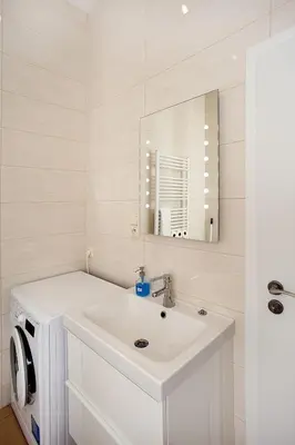 a bathroom with a sink and a washing machine at Celebration Flat by Ruterra in Prague