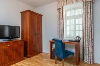 a room with a desk and a television and a chair at St Wenceslas House in Prague