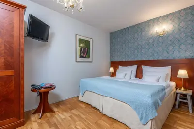 a bedroom with a bed and a tv on a wall at St Wenceslas House in Prague