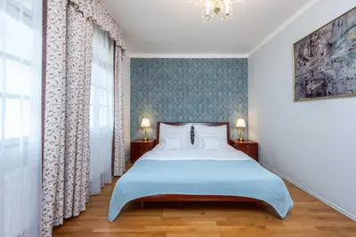 a bedroom with a large bed with a blue blanket at St Wenceslas House in Prague