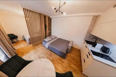 a small bedroom with a bed and a kitchen at Stylish Studio in the city center in Prague