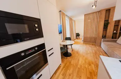 a kitchen with a microwave and a living room at Stylish Studio in the city center in Prague