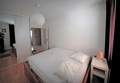 a white bedroom with a bed and a table at Pleasant apartment close to city center in Prague