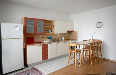 a kitchen with a white refrigerator and a table and chairs at Pleasant apartment close to city center in Prague