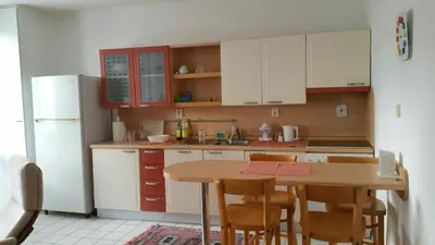 a kitchen with a table and a white refrigerator at Pleasant apartment close to city center in Prague
