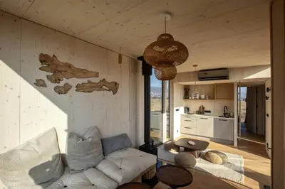 a living room with a white couch and a table at Glamping Jezeroooo Lipence in Prague