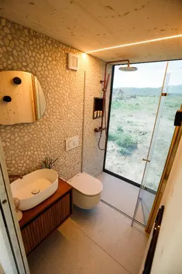 a bathroom with a shower and a toilet and a sink at Glamping Jezeroooo Lipence in Prague
