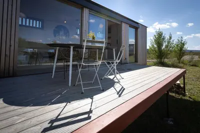 a table and two chairs sitting on a deck at Glamping Jezeroooo Lipence in Prague