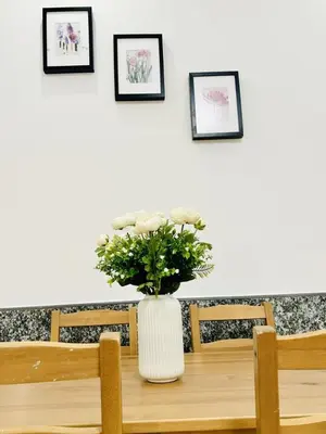 a table with a vase with flowers on it at Helen Homestay Prague 2 in Prague