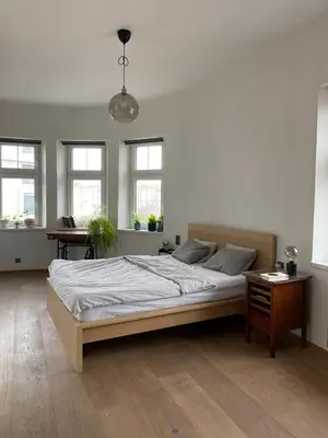 a white bedroom with a large bed and windows at Colorful apartman in Holešovice in Prague