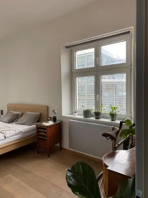 a bedroom with a bed and a window with potted plants at Colorful apartman in Holešovice in Prague