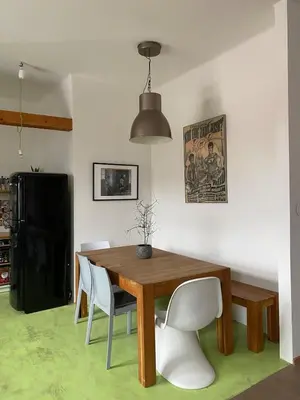 a dining room with a wooden table and white chairs at Colorful apartman in Holešovice in Prague