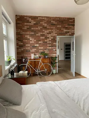 a bedroom with a bike parked against a brick wall at Colorful apartman in Holešovice in Prague
