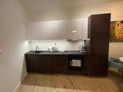 a kitchen with black counters and white cabinets at Stylish 1 bedroom plus office at amazing location in Prague