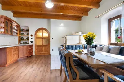 a kitchen and dining room with a wooden table and chairs at Statek u Berků in Svatý Jan