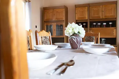 a table with white bowls and a vase of flowers at Statek u Berků in Svatý Jan
