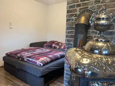 a living room with a bed next to a brick wall at Chata Miracle in Slapy